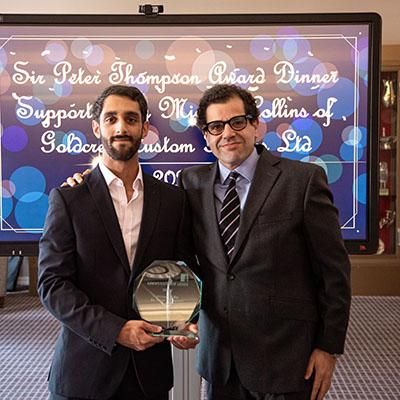 Two people including student founder of Gilly, holding their Sir Peter Thompson award trophy