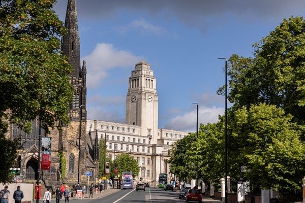 A view of a street with the Parkinson Building in the background, surrounded by trees