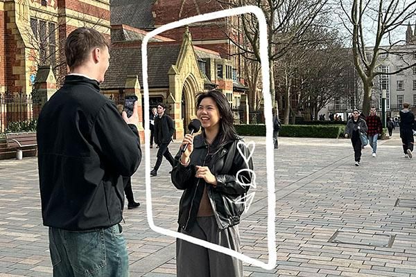 Student Content Creator interviewing another student on campus with a mic. A graphic of a phone screen surrounds one student.